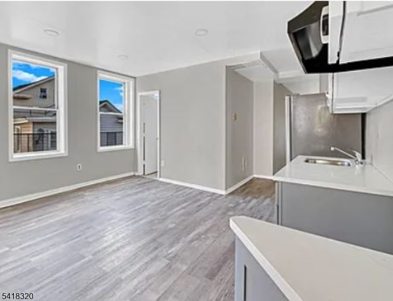 84 Second Street, Unit 4 Elizabeth Port, NJ 07206 - Photo 6 of 16 a view of a kitchen with a sink dishwasher cabinet and a fireplace