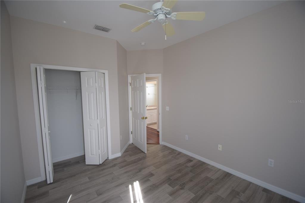 534 Grasslands Village Circle, Unit 534 Lakeland, FL 33803 - Photo 11 of 35 a view of an empty room with wooden floor and fan