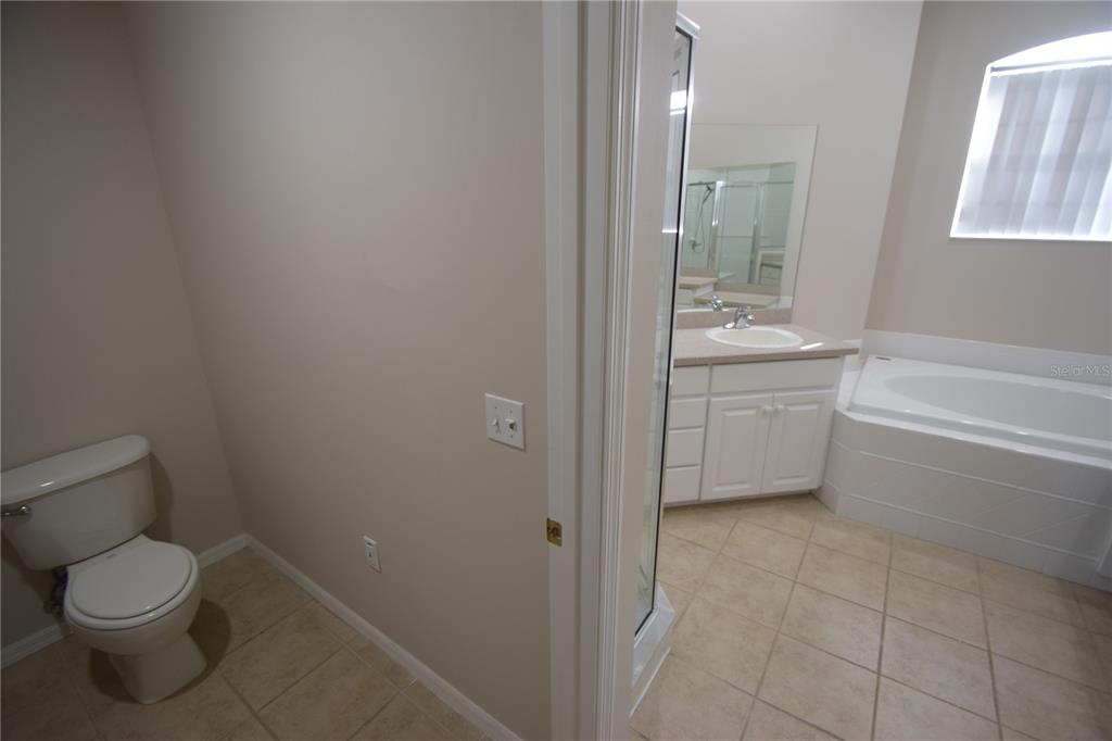 534 Grasslands Village Circle, Unit 534 Lakeland, FL 33803 - Photo 25 of 35 a bathroom with a toilet a sink and bathtub