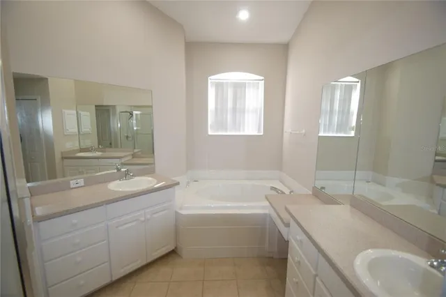 a bathroom with a granite countertop sink mirror and bathtub