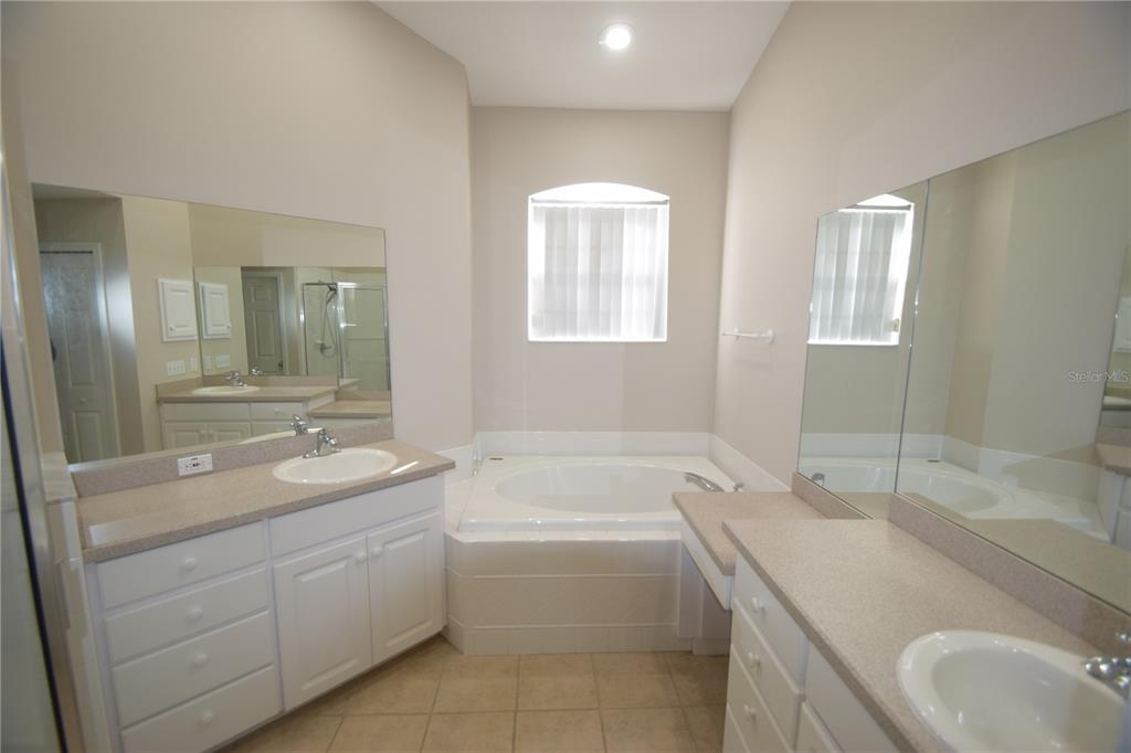 534 Grasslands Village Circle, Unit 534 Lakeland, FL 33803 - Photo 26 of 35 a bathroom with a granite countertop sink mirror and bathtub