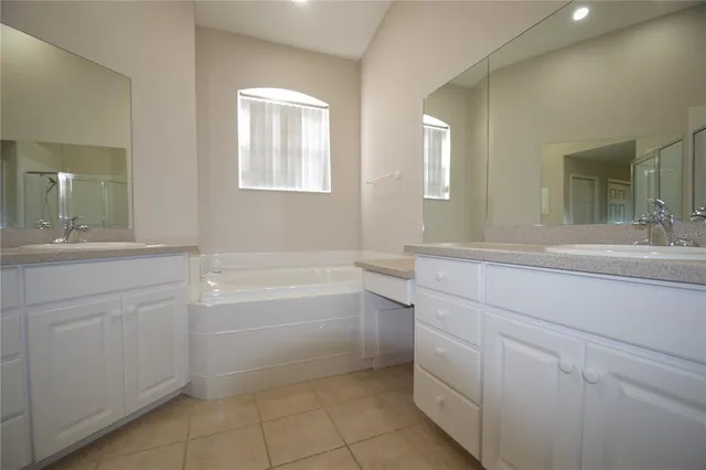 a bathroom with a sink a vanity a mirror and a bathtub
