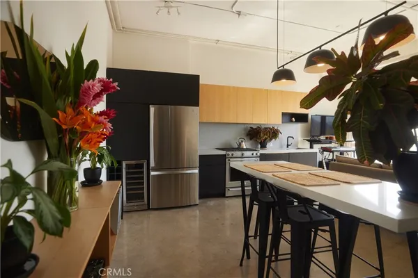 a kitchen with stainless steel appliances granite countertop table chairs and a refrigerator