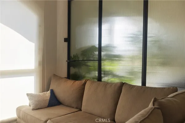 a living room with furniture and a floor to ceiling window