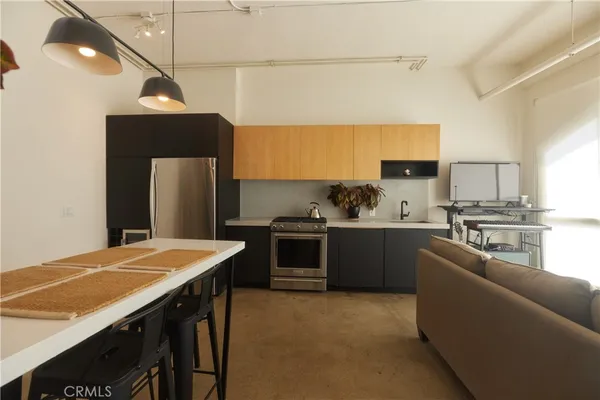 a kitchen with stainless steel appliances a stove a sink cabinets and a refrigerator