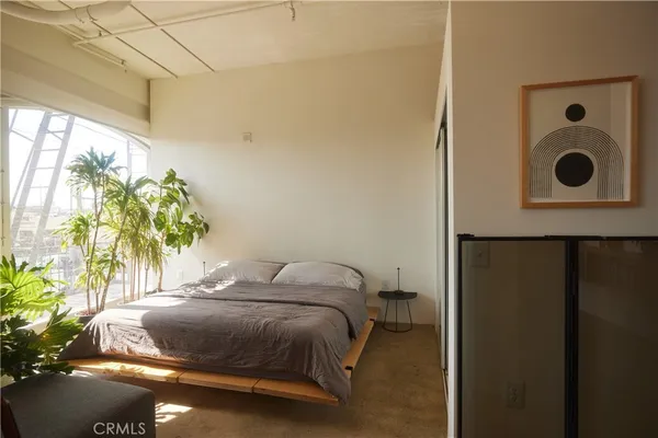 a bedroom with a bed and a potted plant