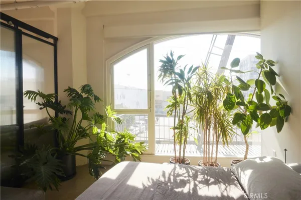 a bedroom with a bed and a potted plant