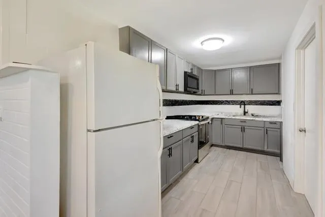 a kitchen with white cabinets and white appliances