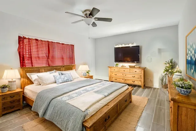 a spacious bedroom with a bed and a flat screen tv