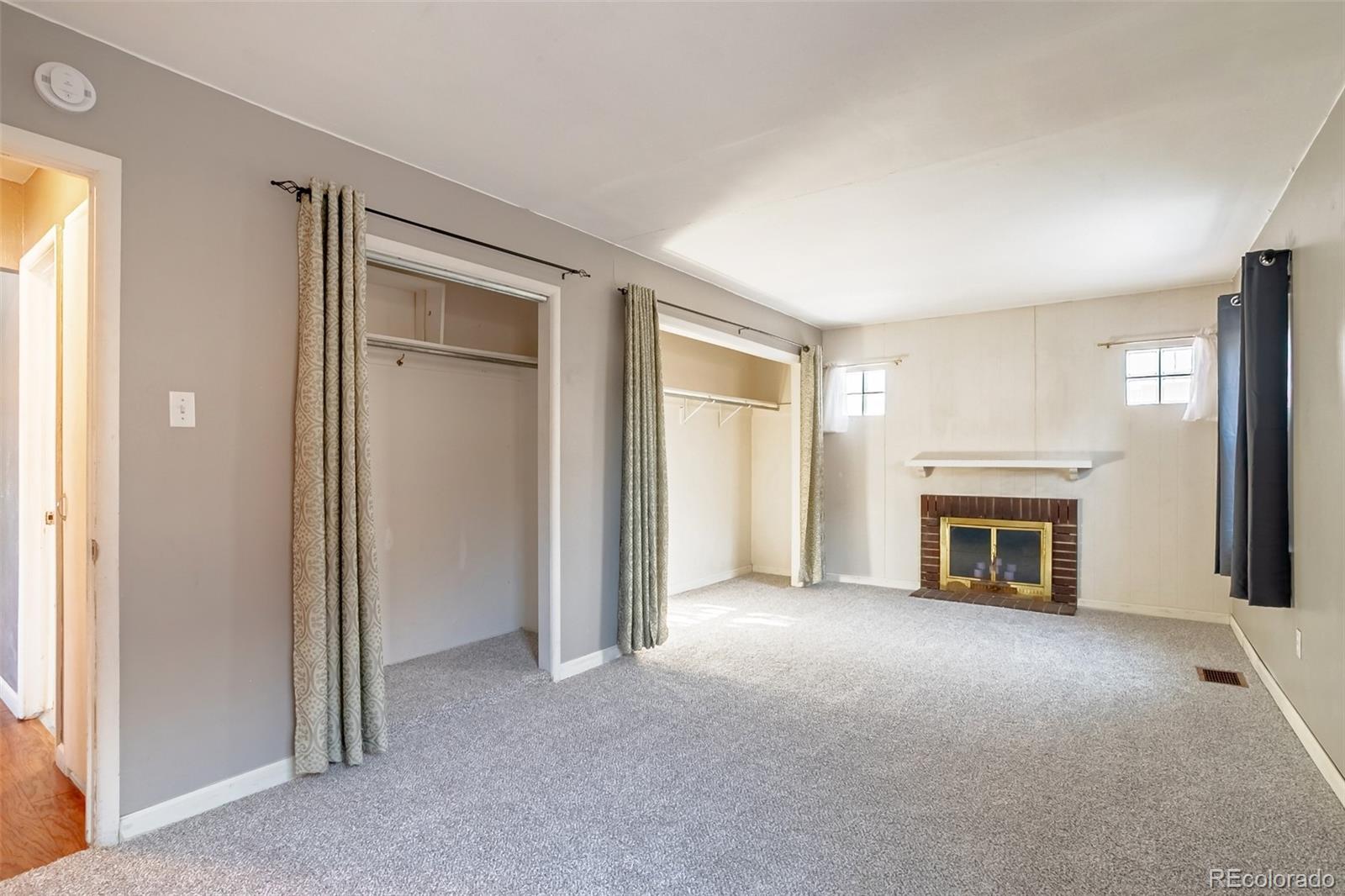 3016 South Grape Way Denver, CO 80222 - Photo 12 of 27 an empty room with fireplace and windows
