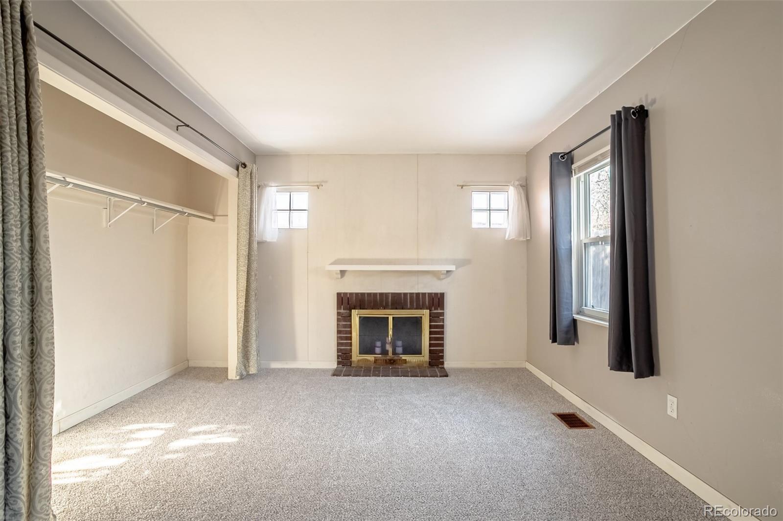 3016 South Grape Way Denver, CO 80222 - Photo 13 of 27 a view of an empty room with a fireplace and a window