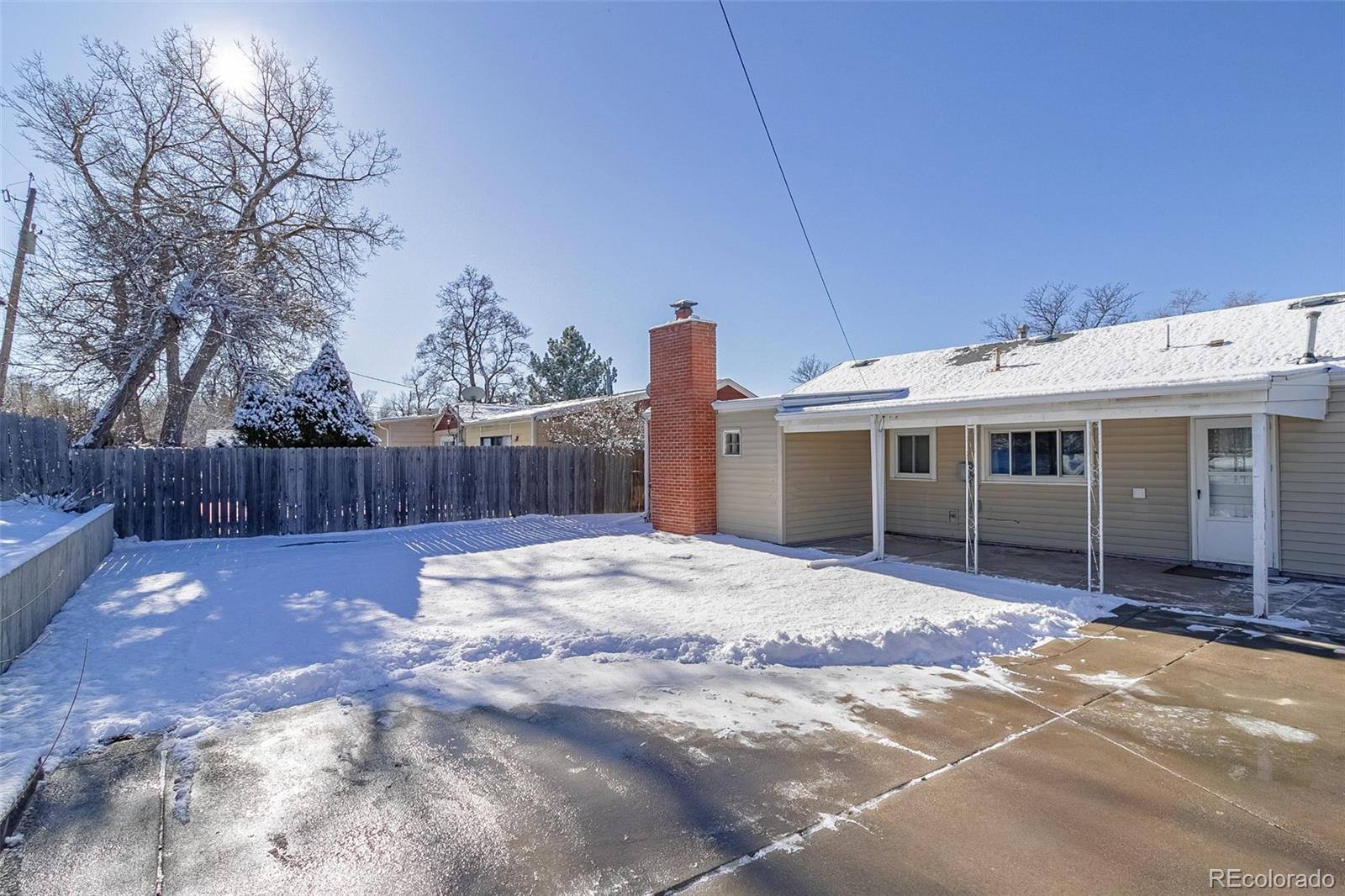 3016 South Grape Way Denver, CO 80222 - Photo 21 of 27 a front view of a house with a yard and garage