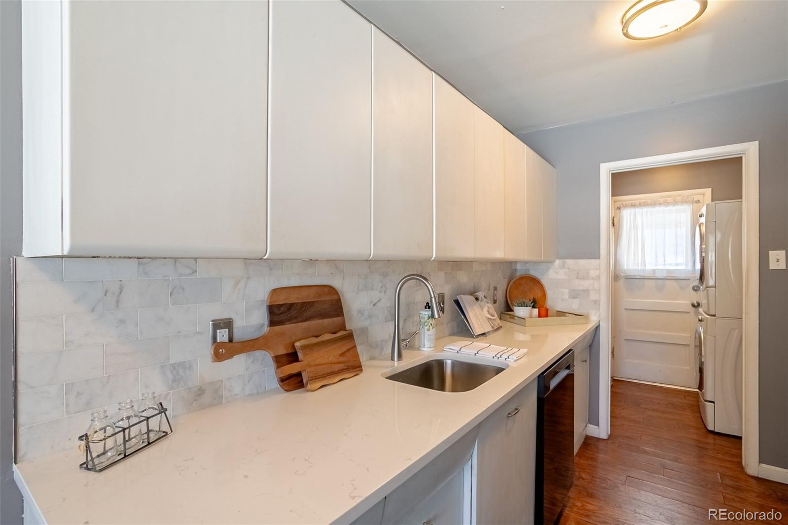 3016 South Grape Way Denver, CO 80222 - Photo 5 of 27 a kitchen with stainless steel appliances granite countertop a sink stove and cabinets