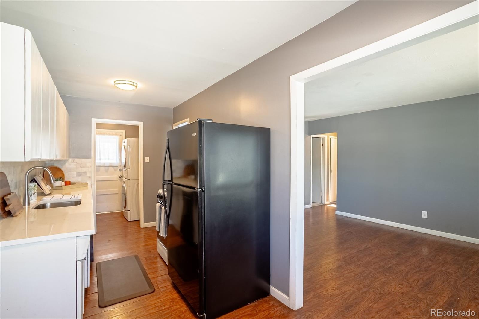 3016 South Grape Way Denver, CO 80222 - Photo 7 of 27 a kitchen with a refrigerator and a sink