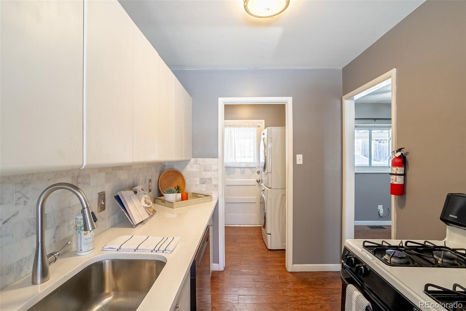 3016 South Grape Way Denver, CO 80222 - Photo 8 of 27 a kitchen with stainless steel appliances granite countertop a sink stove and refrigerator