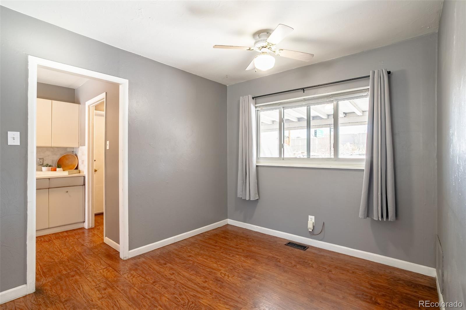 3016 South Grape Way Denver, CO 80222 - Photo 10 of 27 a view of an empty room with window and wooden floor