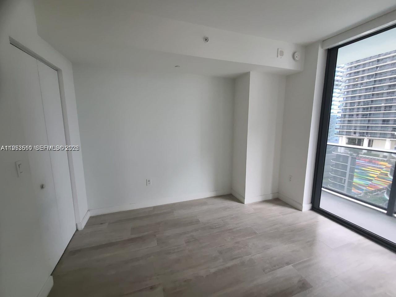 55 Southwest 9th Street, Unit 1502 Miami, FL 33130 - Photo 5 of 6 a view of an empty room with a window