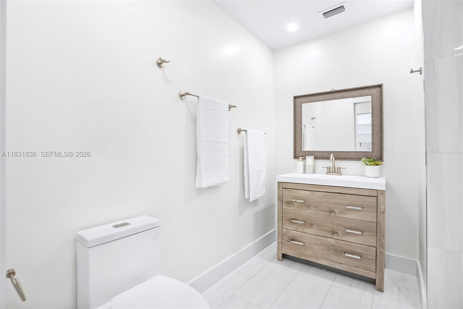 7829 La Mirada Drive Boca Raton, FL 33433 - Photo 16 of 26 a bathroom with a sink a toilet and a mirror