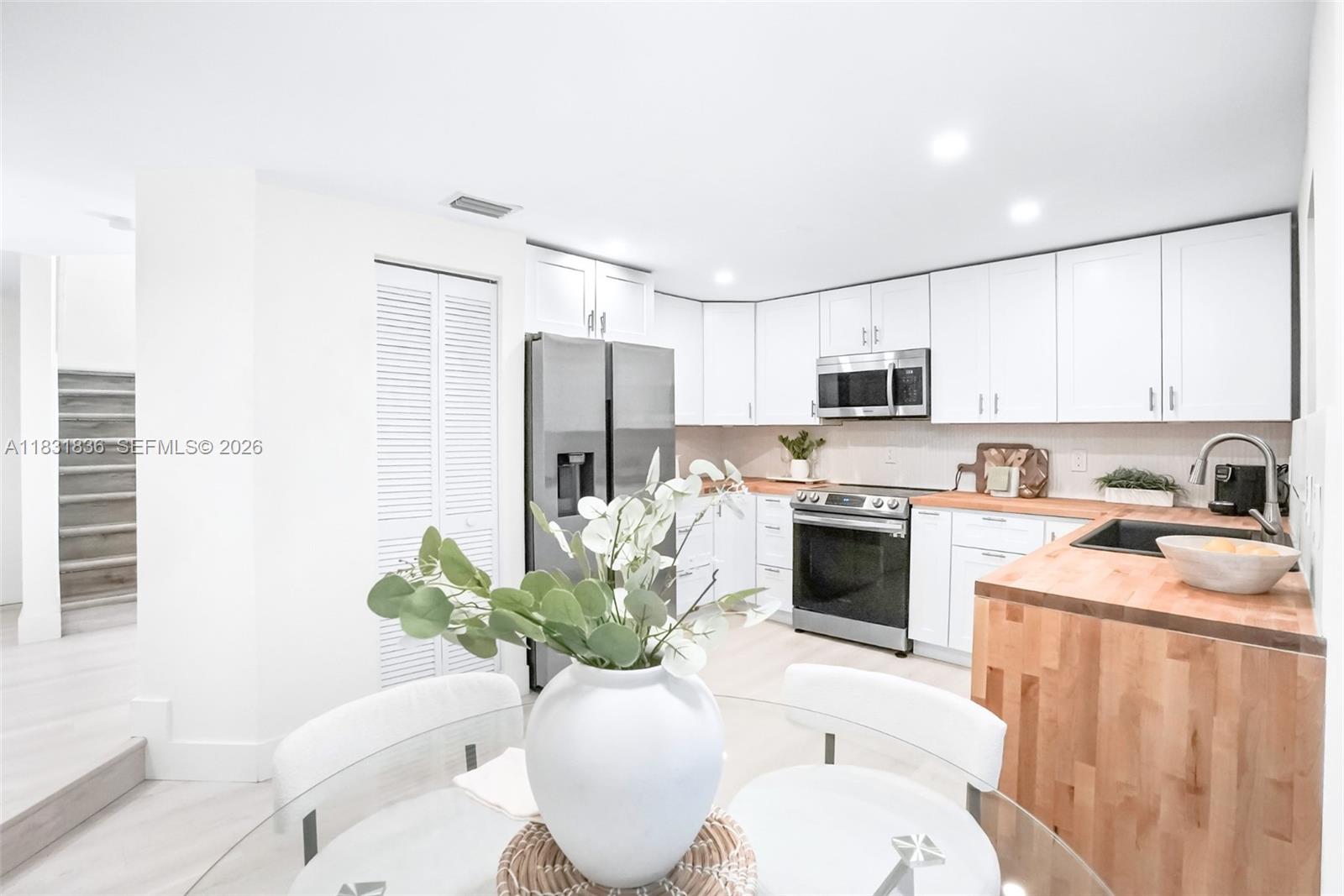 7829 La Mirada Drive Boca Raton, FL 33433 - Photo 8 of 26 a kitchen with stainless steel appliances a stove a sink a microwave a refrigerator a dining table and chairs