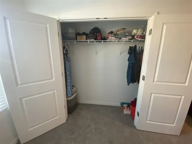 a view of a hallway with closet and refrigerator