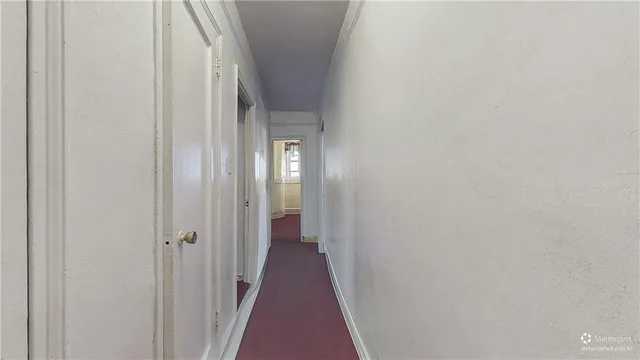 an empty room with windows and chandelier fan