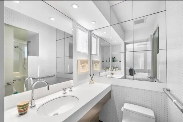 a bedroom with a bed and a lamp on dresser