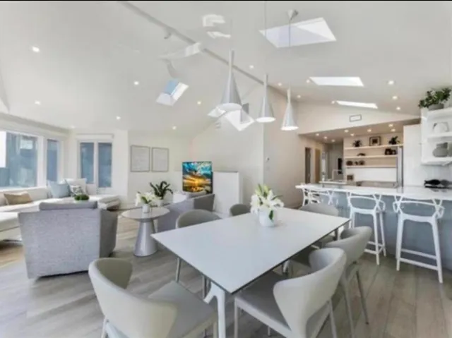 a living room with furniture wooden floor and a floor to ceiling window