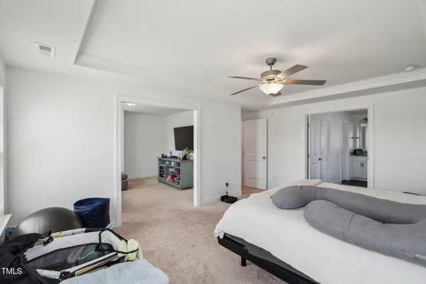 a bedroom with a bed couches chair and a chandelier