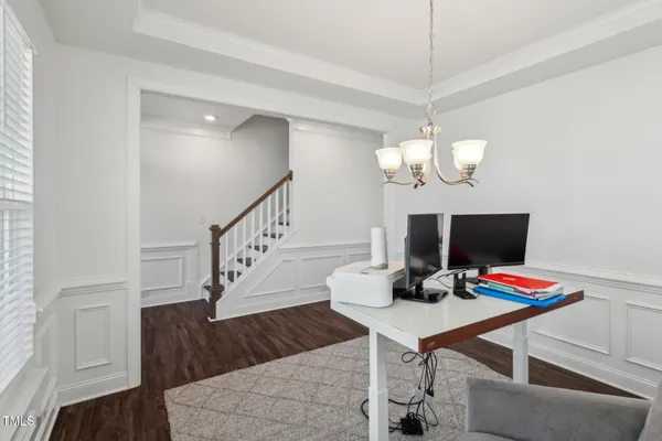 a dining room with furniture a chandelier and wooden floor
