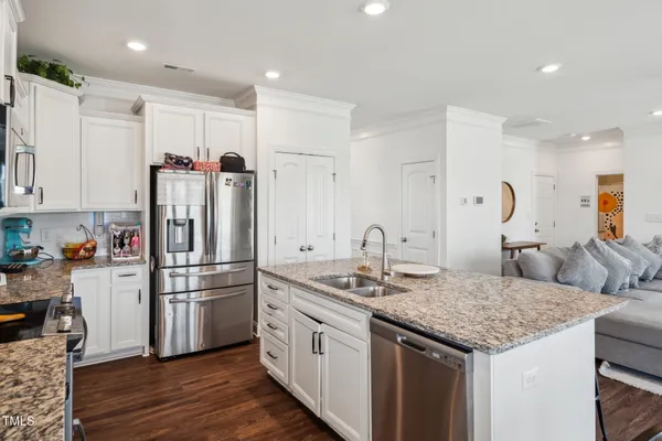a kitchen with kitchen island granite countertop a table chairs microwave and cabinets