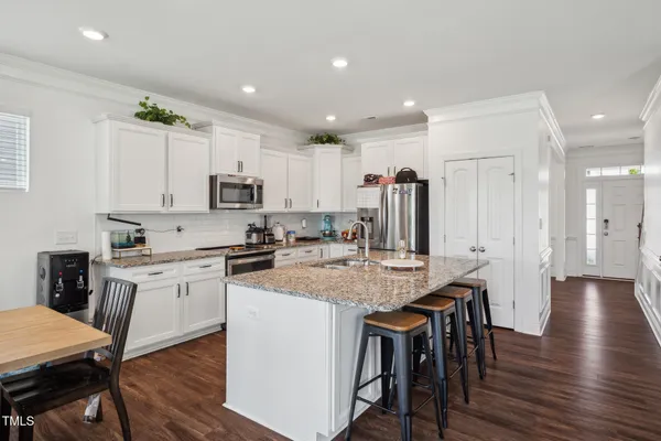 a kitchen with stainless steel appliances granite countertop a sink refrigerator and cabinets