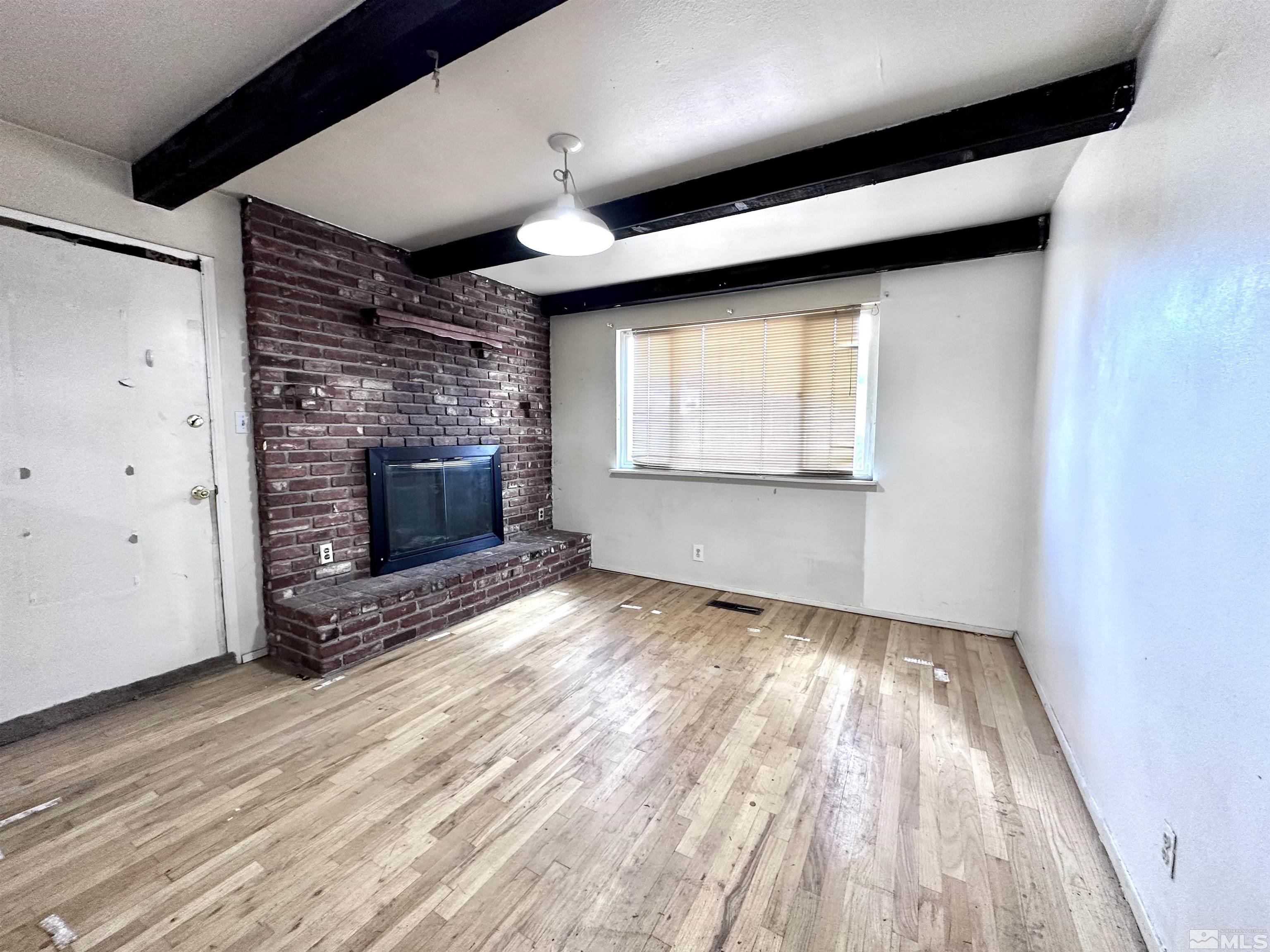 1202 Wilkinson Reno, NV 89503 - Photo 12 of 31 an empty room with windows fireplace and a ceiling fan