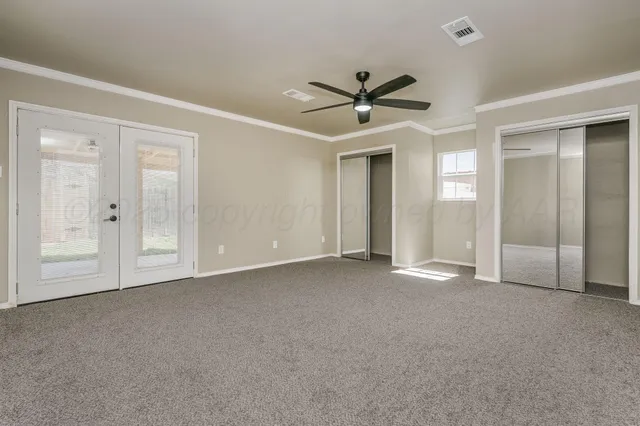 a view of an empty room with a ceiling fan