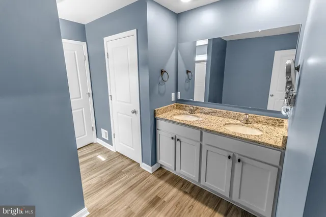 a bathroom with a granite countertop sink and a mirror
