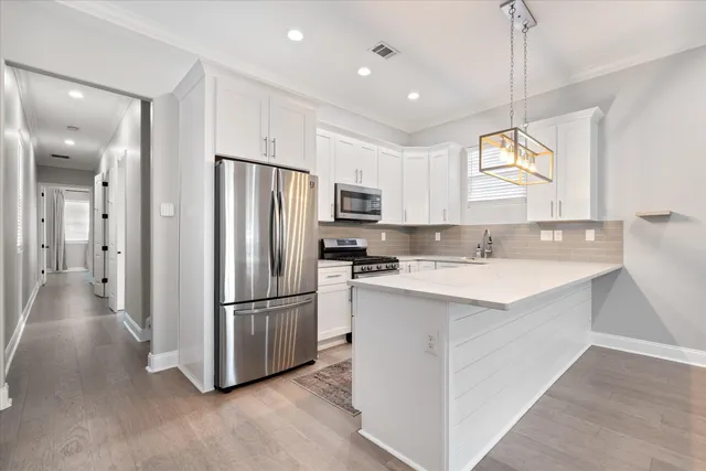 a kitchen with kitchen island a refrigerator and a sink