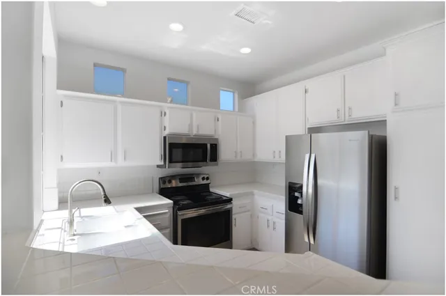 a kitchen with stainless steel appliances a refrigerator stove microwave and sink