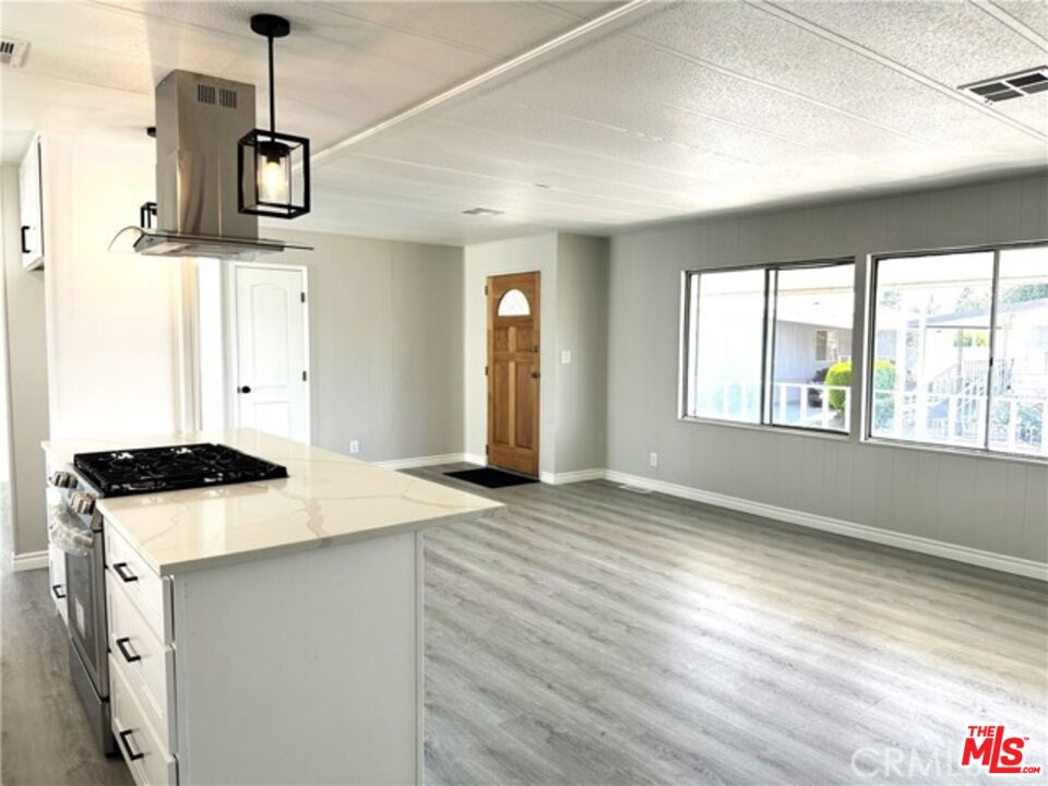 9391 California Avenue, Unit 89 Riverside, CA 92503 - Photo 5 of 16 a kitchen with a stove and a wooden floor