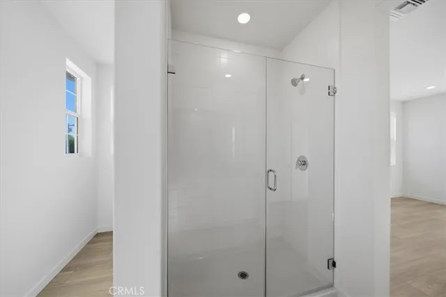 a bathroom with a shower and a glass door