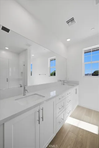 a bathroom with a granite countertop double vanity sink and mirror