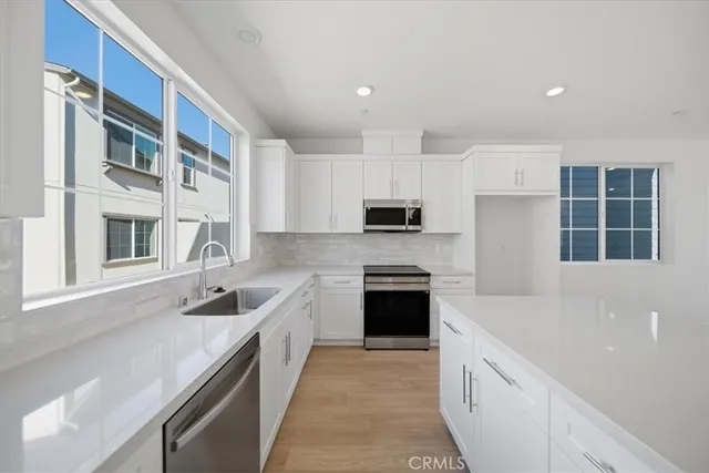 a kitchen with stainless steel appliances granite countertop a sink and a stove top oven