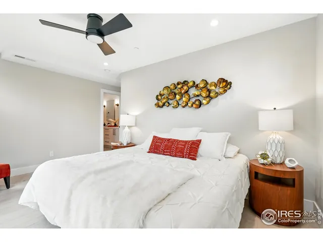 a bedroom with a bed and a lamp on dresser