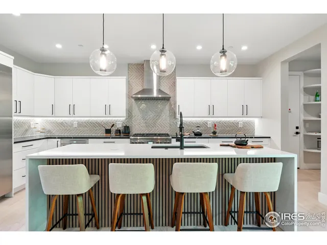 a kitchen with kitchen island granite countertop a sink a counter space cabinets and stainless steel appliances