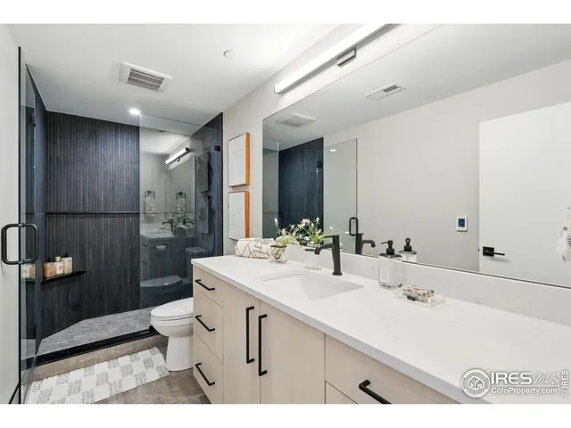a bathroom with a double vanity sink toilet and shower