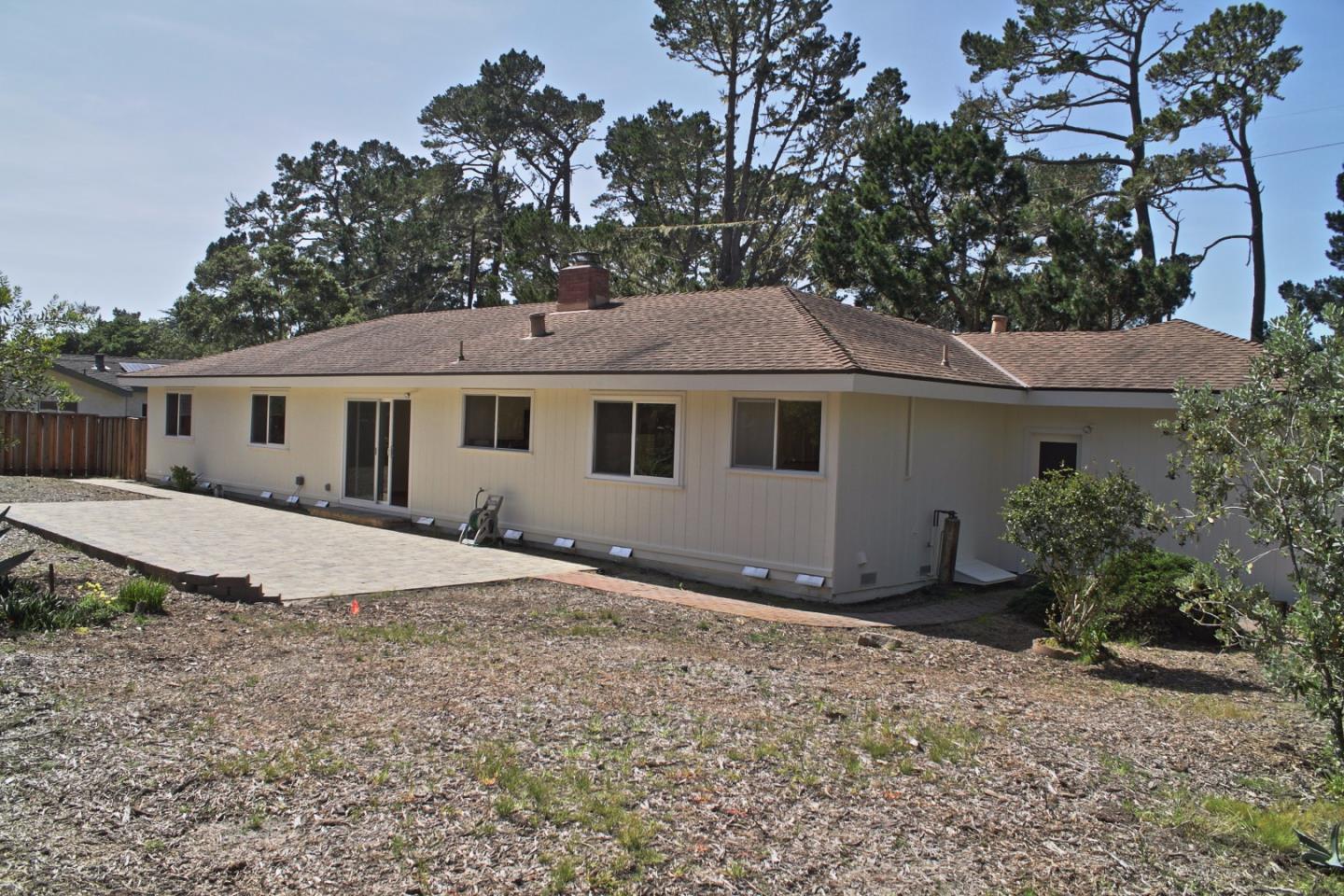 3035 Sloat Road Pebble Beach, CA 93953 - Photo 6 of 16 a front view of a house with a garden and yard
