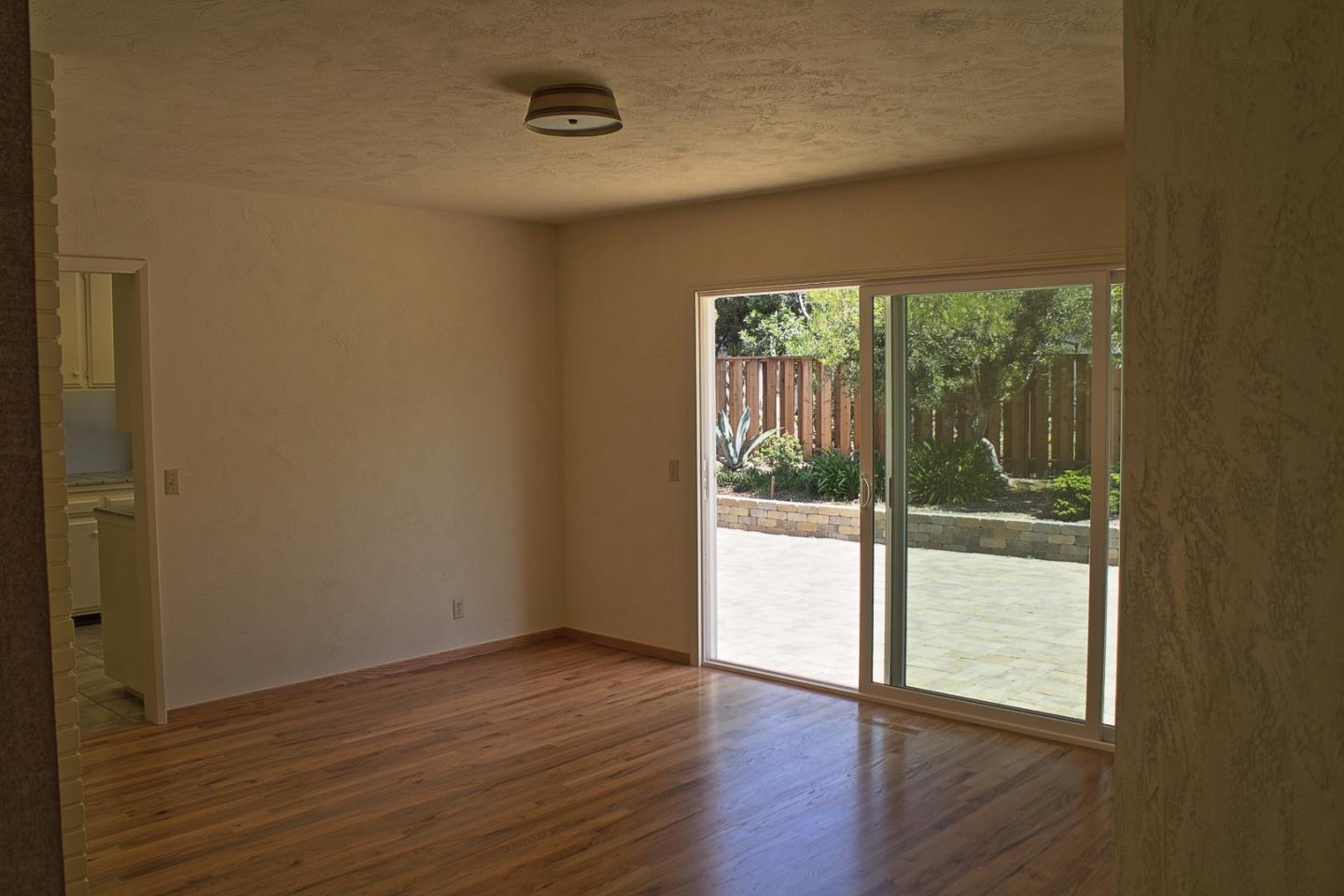 3035 Sloat Road Pebble Beach, CA 93953 - Photo 9 of 16 a view of an empty room with wooden floor and a window