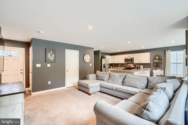 a living room with furniture and view of kitchen