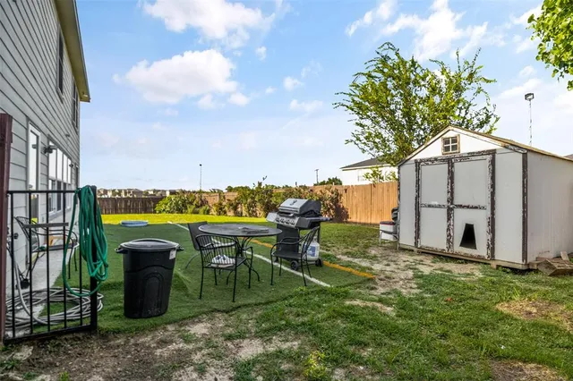 a view of a patio with table and chairs potted plants with wooden fence