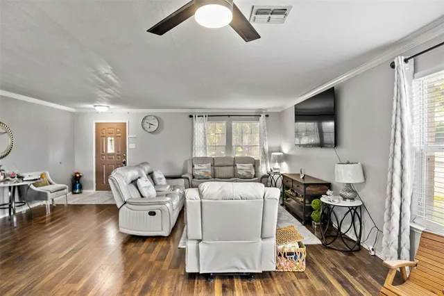 a living room with furniture and wooden floor