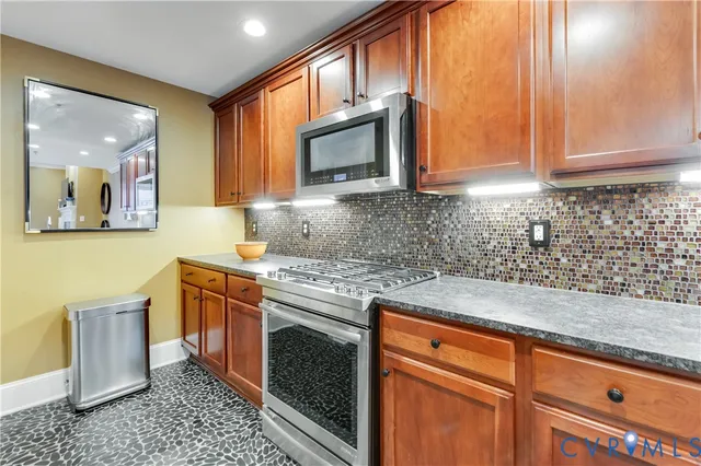 a kitchen with stainless steel appliances granite countertop a sink stove and microwave