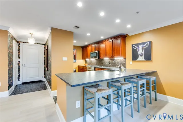 a kitchen with stainless steel appliances granite countertop a sink and a refrigerator